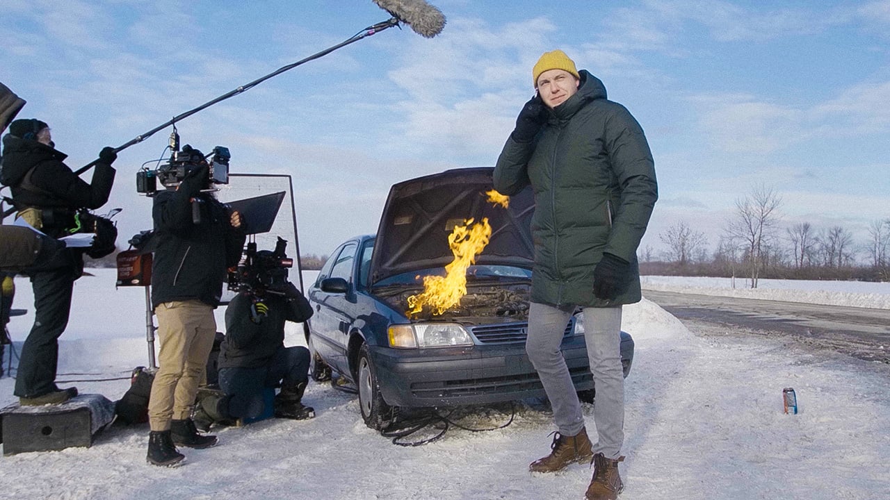 Alex Lapointe standing in front of a burning car