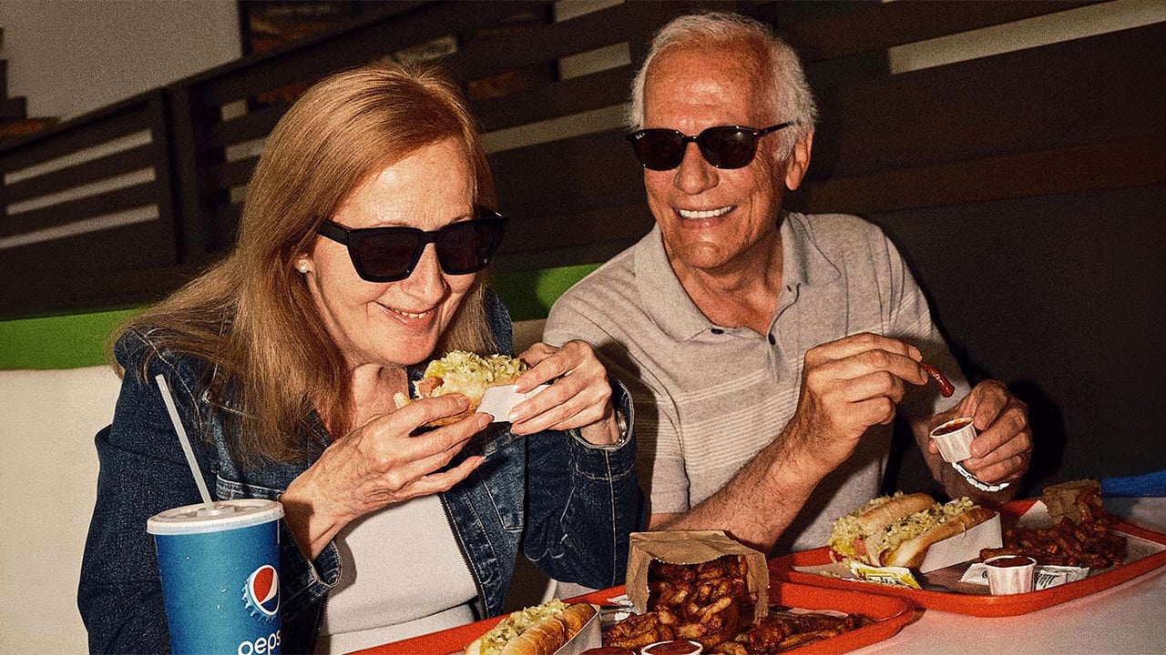 Two older customers eating a hot dog in a Lafleur restaurant